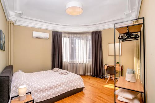 a bedroom with a bed and a desk and a chair at Stunning Luxury 3 Bedroom Apt in the Heart of Town in Sofia