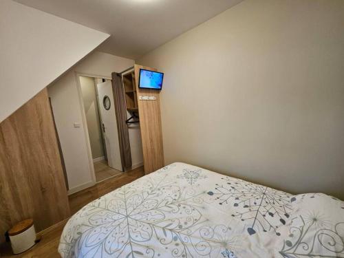 a bedroom with a bed and a television on the wall at Le 301 Vercingétorix - Proche Paris & Disney in Champigny-sur-Marne