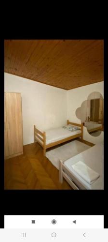 a room with two beds and a wooden ceiling at Vlado apartments in Podgorica