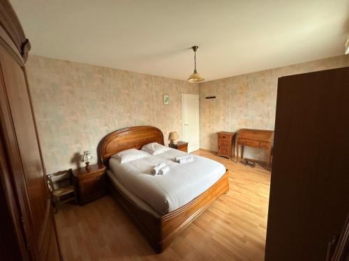 Cette chambre comprend un lit avec des draps blancs et du parquet. dans l'établissement La villa d'Este, à La Rochelle