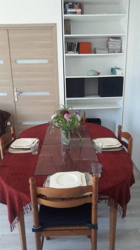 una mesa con un jarrón de flores encima en Superbe chambre confortable et lumineuse en appartement, en Bry-sur-Marne