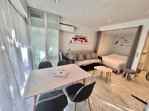 Cette chambre comprend un lit, une table et des chaises. dans l'établissement Jolies Lavandes, by Welcome to Cannes, à Cannes