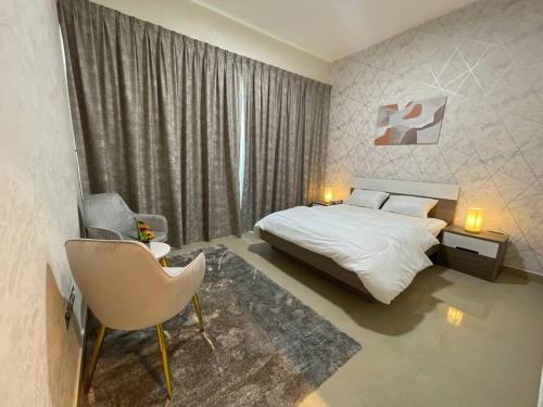 een slaapkamer met een bed, een stoel en een raam bij Nearest to the Airport l Beautiful 1 BR Apt in Abu Dhabi