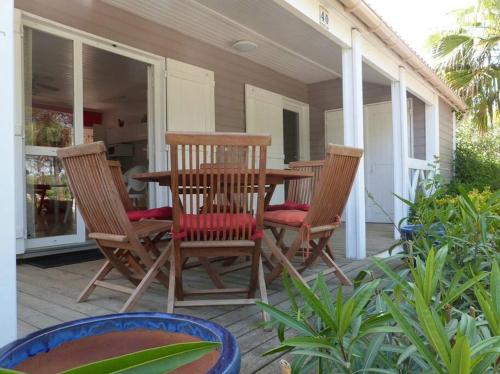 une table et des chaises en bois sur une terrasse dans l'établissement GASMED40 - Golfe de St-Tropez - Chalet californien pour 6 personnes situé dans un parc arboré à Gassin, à Gassin