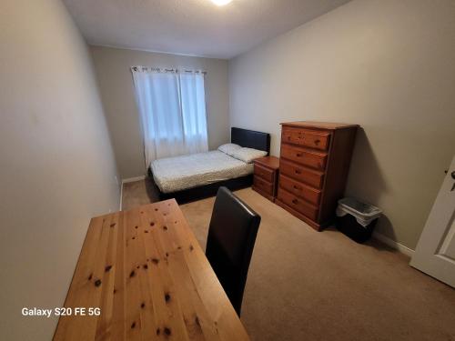 1 dormitorio con mesa, 1 cama y vestidor en Private Room 2, en Ottawa