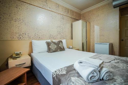 1 dormitorio con 1 cama con toallas en SAHRA OTEL, en Estambul