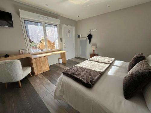 a bedroom with a large bed and a window at Hôtel La Rencluse in Luchon