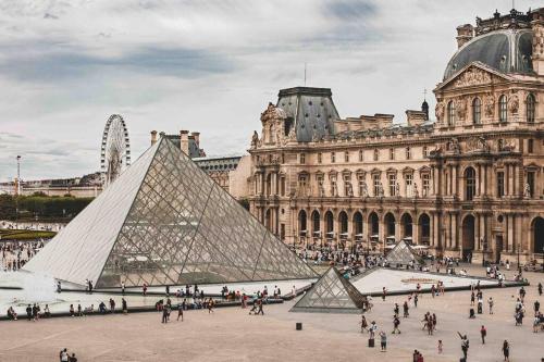 uma vista para a pirâmide de Louvre em frente a um edifício em Appartement charmant proche Paris em Ivry-sur-Seine