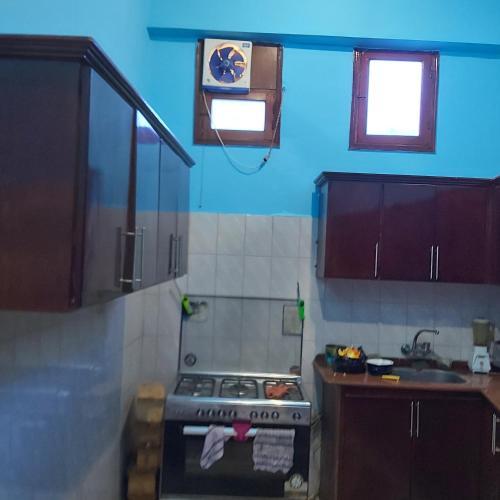 - une cuisine avec une cuisinière et un mur bleu dans l'établissement Happy home, à Louxor