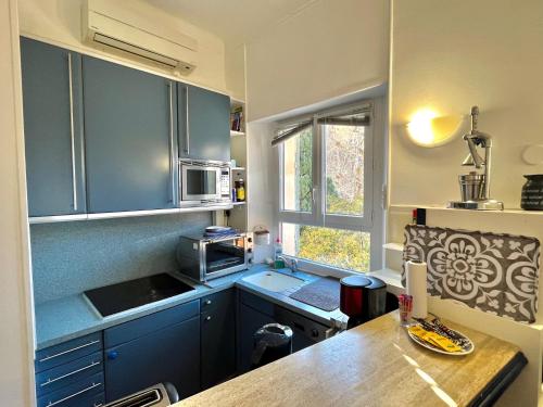 une cuisine avec des armoires bleues et un comptoir dans l'établissement Cannes Suquet by Welcome to Cannes, à Cannes