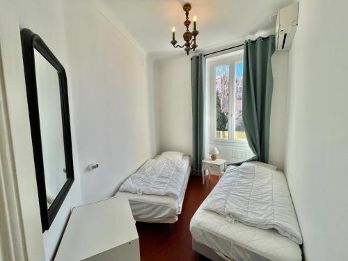 une chambre avec deux lits et une fenêtre dans l'établissement Cannes Suquet by Welcome to Cannes, à Cannes