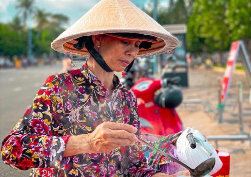 an older woman wearing a hat and glasses at The Song VT Beach Apartment in Vung Tau