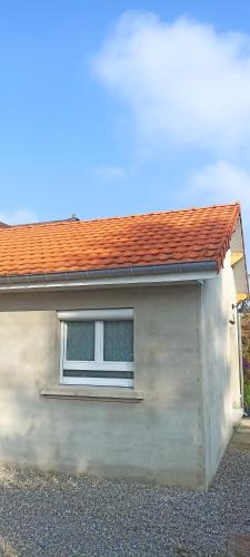 una casa bianca con finestra e tetto rosso di Ravissante suite avec terrasse, parking sur place a Danjoutin