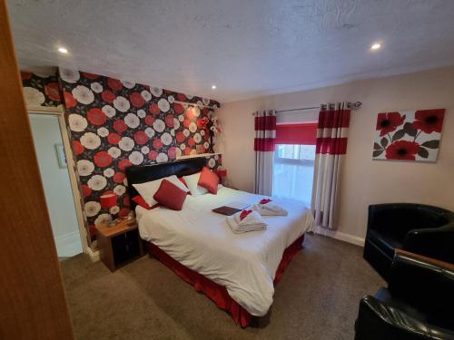 a bedroom with a large bed with red pillows at The Fawley Guest house in Shanklin