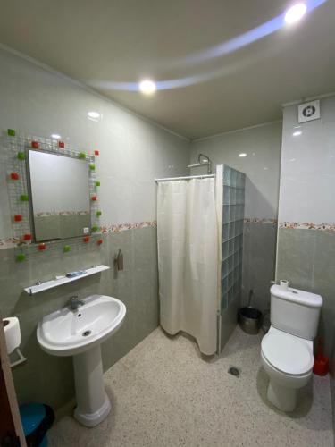 a bathroom with a toilet and a sink and a mirror at Hostel Apart in Dar el Beïda