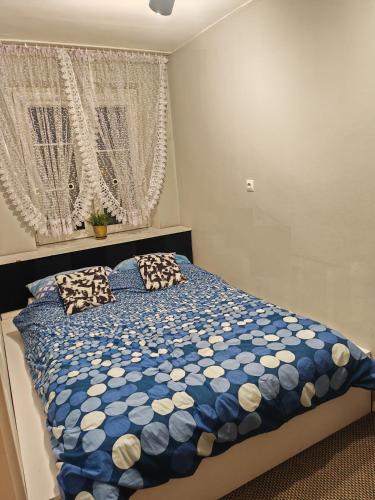 Un dormitorio con una cama azul y blanca con almohadas en Apartament Chełmsko en Chełmsko Śląskie