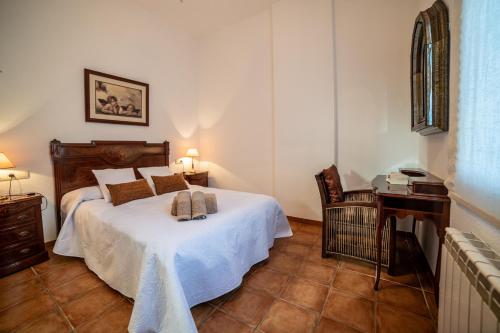 een slaapkamer met een bed, een tafel en een bureau bij Casa el Refugio del Lago alojamiento rural in Córdoba