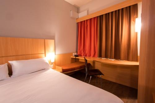 a hotel room with a bed and a desk at ibis Presidente Prudente Manoel Goulart in Presidente Prudente