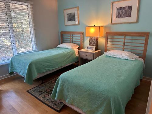 1 dormitorio con 2 camas y lámpara. en 68 Inlet Cove, en Kiawah Island