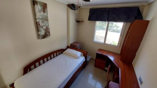 Habitación pequeña con cama y ventana en Villa Paradise Campello, en El Campello