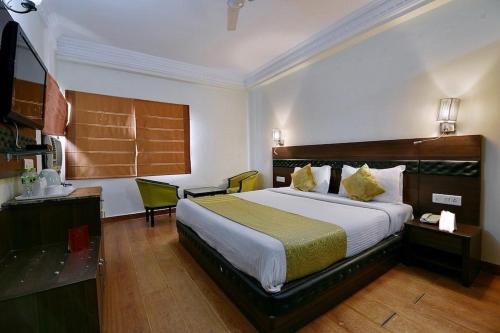 Habitación de hotel con cama grande y TV en Hotel Empire Regency en Jaipur