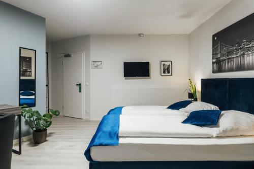 a bedroom with a large bed with blue pillows at Hotel im Hegen in Oststeinbek