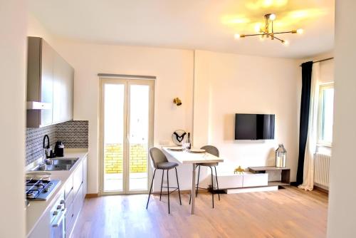 a kitchen with a table and chairs in a room at VUEL SEA VIEW HOUSE -10 Minutes from the Airport Fiumicino in Fiumicino