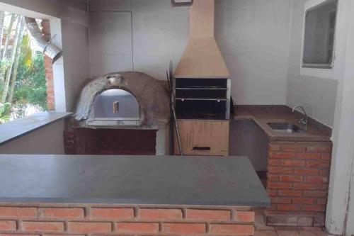 a kitchen with a brick counter and an oven at Espaço Geraldo Meirelles in Casa Branca