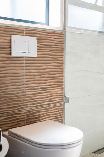 a bathroom with a white toilet and a window at Lemon Tree Studio 991 in Langebaan