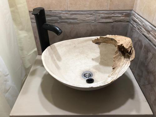 a sink in a bathroom with a wooden cut out at La Comarca Aparts Alojamiento in Colón