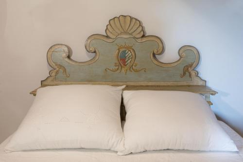 a bed with a headboard and two white pillows at Dimora Rosa Bianca in Macerata