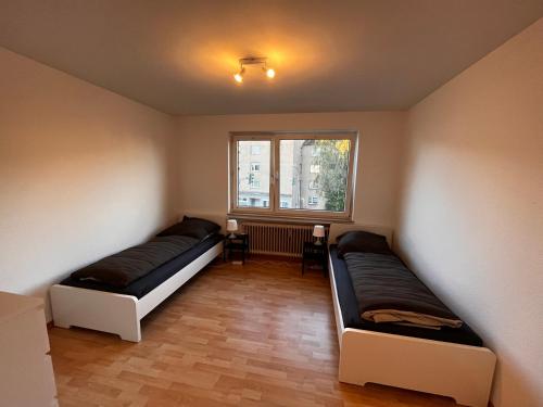 twee bedden in een kamer met een raam bij Optimale Monteursunterkunft in Remscheid