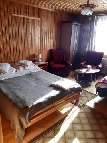 a bedroom with a bed and a living room at Pokoje u Marysi in Szaflary