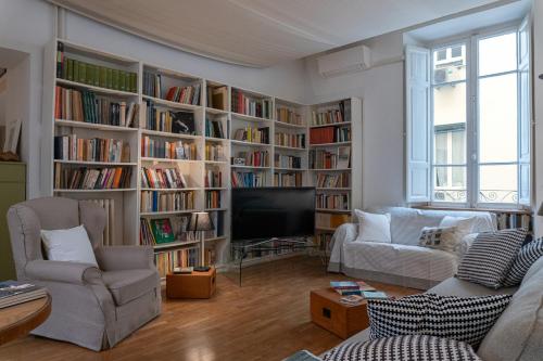 uma sala de estar com estantes de livros cheias de livros em Gallery Apartment, Near The Vatican em Roma