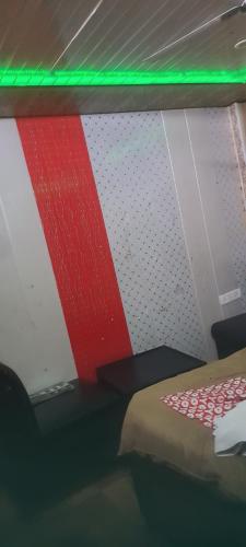 a room with a bed with a red and white wall at S R HOTEL & RESTAURANT in Lucknow