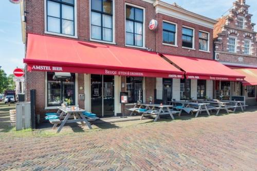un edificio con mesas de picnic delante de él en Hotel Monnickendam en Monnickendam