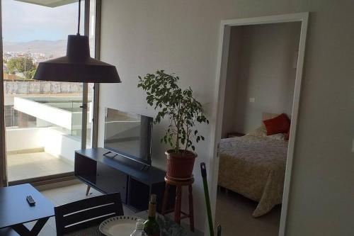 1 dormitorio con escritorio, 1 cama y espejo en Hermoso departamento ful amueblado nivel ejecutivo en Antofagasta