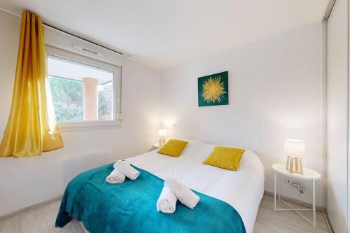 - une chambre blanche avec un lit et 2 serviettes dans l'établissement My Cozy Flat - Côté Jardin - Parking - Terrasse, à Toulouse