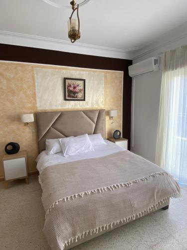 a bedroom with a large bed and a large window at Hostel Apart in Dar el Beïda