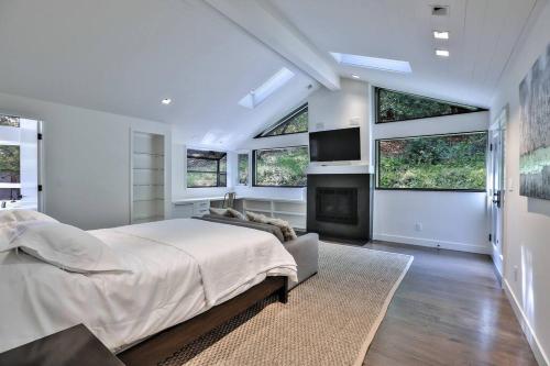 een slaapkamer met een groot bed en ramen bij Stunning Executive Retreat 5b/4ba —Entire Home in Portola Valley