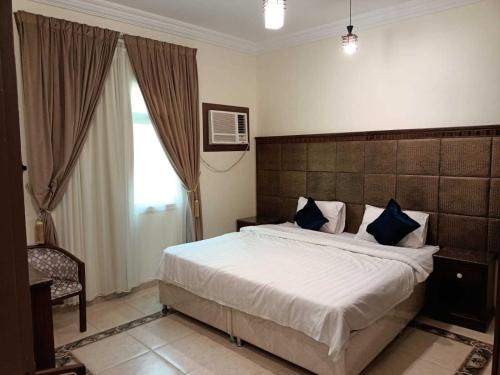 um quarto com uma cama grande e almofadas azuis em آفاق التميز em Jidá