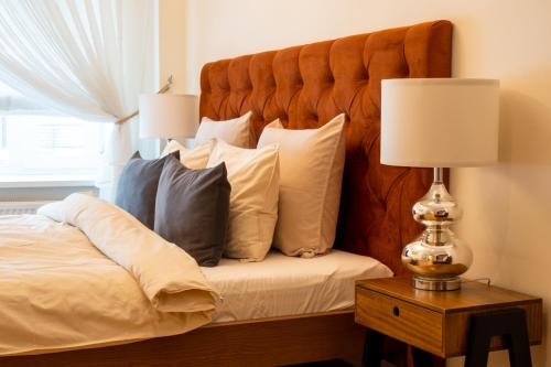 1 dormitorio con 1 cama con almohadas y lámpara en Design apartment en Liepāja