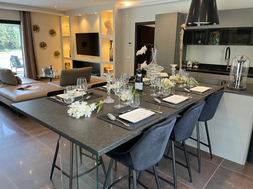a large table with chairs and glasses on it in a kitchen at Domaine de La Franquette by Bridget & Pascal - Piscine Chauffée & SPA in Caderousse