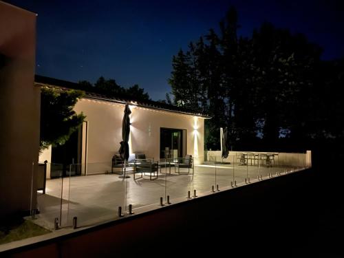 a patio with a table and chairs at night at Domaine de La Franquette by Bridget & Pascal - Piscine Chauffée & SPA in Caderousse