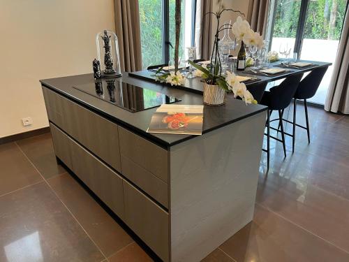 a kitchen with a island with a black counter top at Domaine de La Franquette by Bridget & Pascal - Piscine Chauffée & SPA in Caderousse