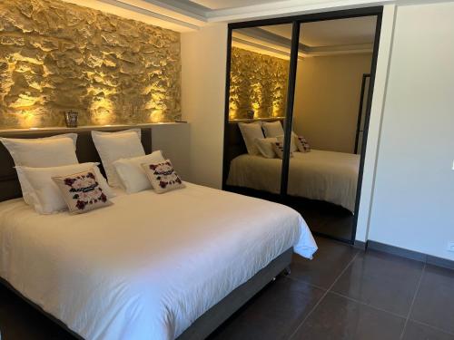 a hotel room with two beds and a mirror at Domaine de La Franquette by Bridget & Pascal - Piscine Chauffée & SPA in Caderousse