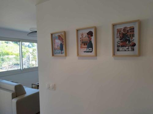 three pictures on a wall in a living room at Appartement moderne refait à neuf - 4 couchages - MENTON in Menton