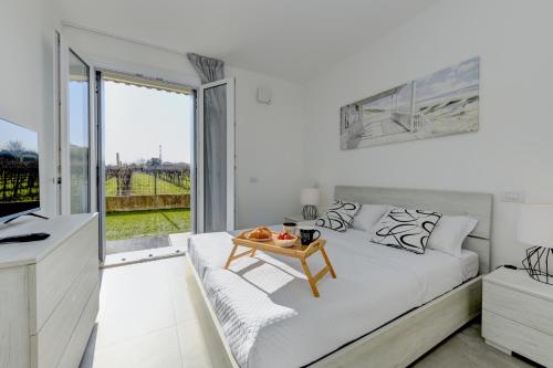 a white bedroom with a bed and a table at New Apartment Lazise in Lazise