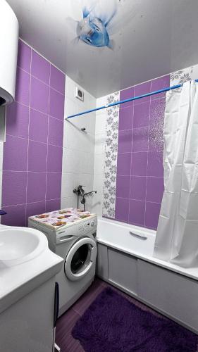 a purple bathroom with a toilet and a shower at Quiet appartment in Bishkek city in Bishkek