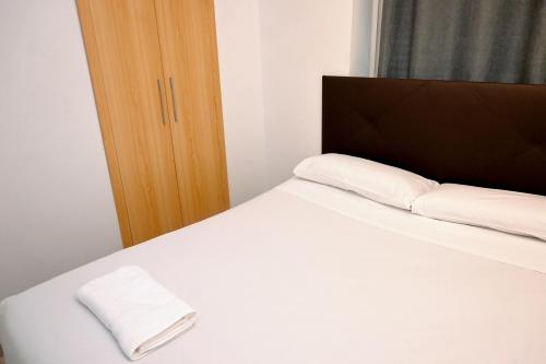 巴塞隆納的住宿－Homenfun Barcelona Guinardó Hospital Sant Pau，一间卧室配有一张带两个枕头的床